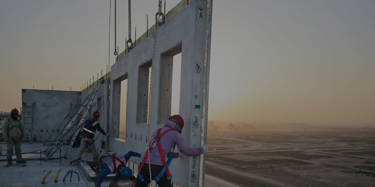 Skilled crew positioning a precast wall panel during installation, supported by Burkes’ crane rental services.