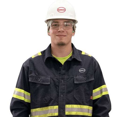 Burkes Mechanical worker in dark reflective safety uniform, safety glasses, and hard hat.
