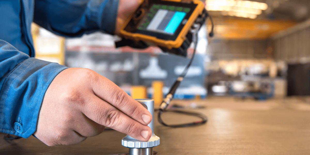 Technician performing precision instrument calibration with handheld device in an industrial facility, representing Burkes instrumentation services