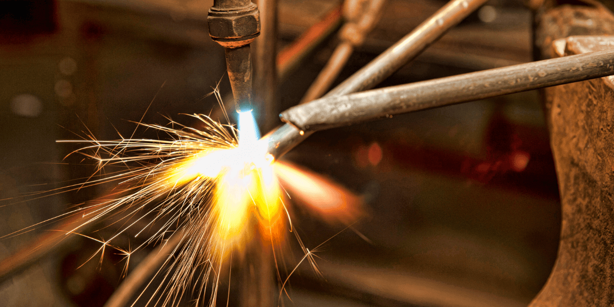 Industrial fabrication shop welding and assembling structural steel and piping, representing certified pipe, tank, and vessel fabrication services.