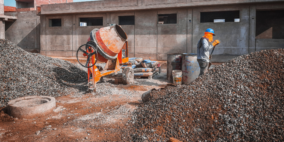Worker at a concrete site performing foundation installation, representing Burkes Mechanical’s industrial civil construction services for durable, on-schedule builds.
