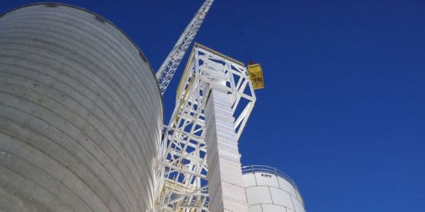 Burkes Mechanical industrial crane lifting and setting large storage tank at a manufacturing facility, supporting heavy equipment installation and capital projects across the Southeast