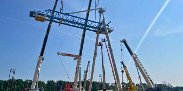 Multiple Burkes Mechanical cranes performing a precision coordinated heavy lift of a large industrial gantry platform structure in the Southeast US, demonstrating certified crane rental services with a fleet capable of complex lifts up to 300 tons