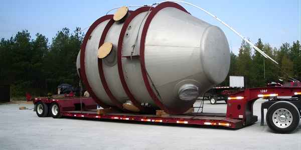 Burkes Mechanical fabricated oversized industrial vapor head pressure vessel secured with rigging straps on a lowboy trailer for transport to an industrial site in the Southeast US, demonstrating large scale custom vessel fabrication and certified delivery services